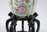 Cachepot de porcelana oriental decorado com flo... - Cachepot de porcelana oriental decorado com flores e figuras típicas em policromia, base de madeira. Apresenta restauro.