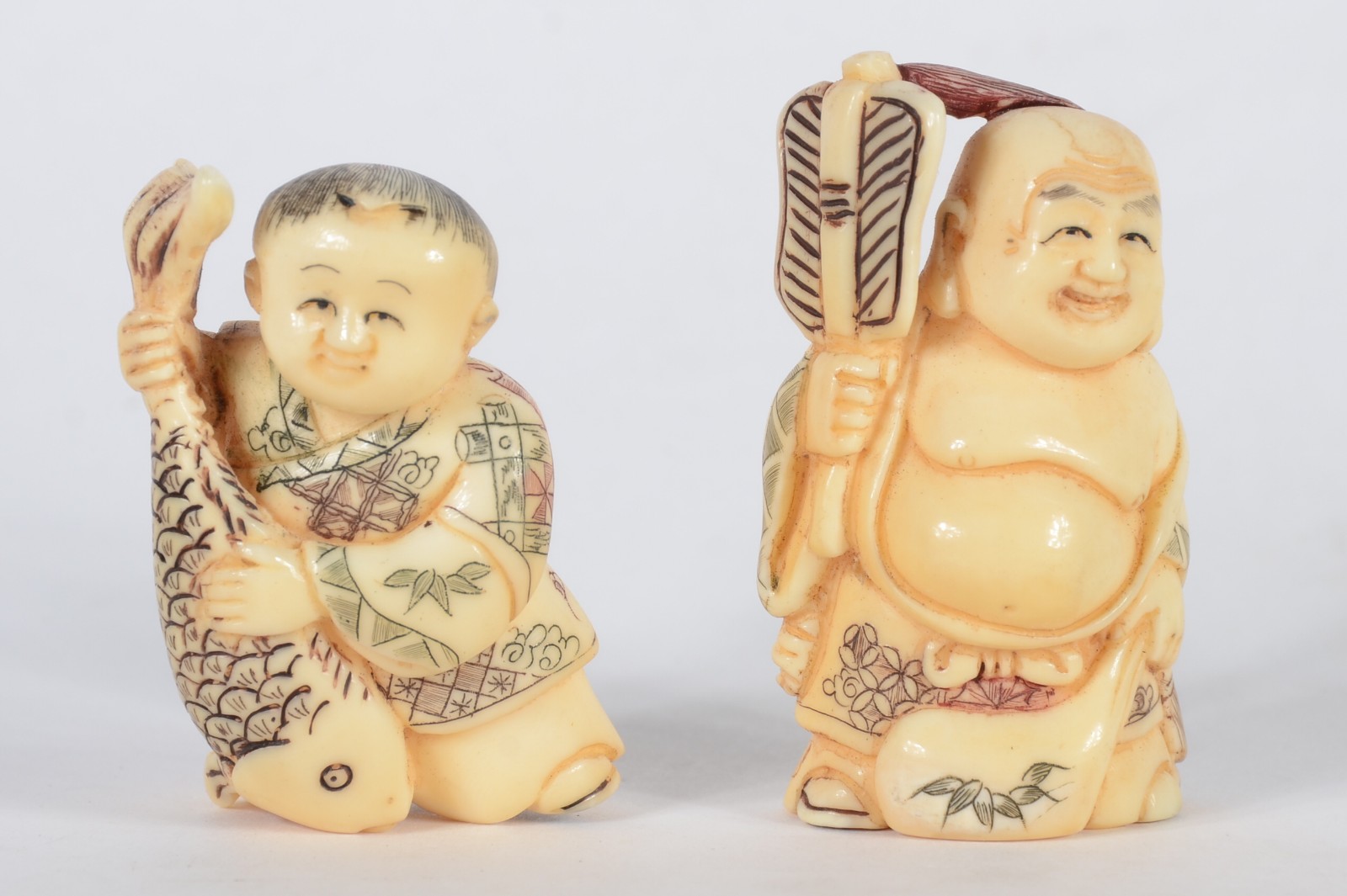 Dois netsukes de marfim representando figuras com peixe e ventarola... - foto 1 de 5