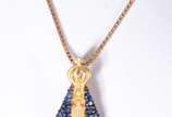 Colar com pendente de Nossa Senhora Aparecida c... - Colar com pendente de Nossa Senhora Aparecida com mano azul de ouro 18 k., contraste 750 mls. (Por motivos de segurança a peça não se encontra n...