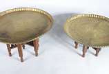 Duas mesas orientais com tampos de metal e base... - Duas mesas orientais com tampos de metal e bases de madeira trabalhada. Desgastes.