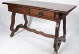 Mesa de escritório de madeira nobre com duas ga... - Mesa de escritório de madeira nobre com duas gavetas com puxadores de metal, pernas na forma de liras unidas por trave inferior recortada. Estil...