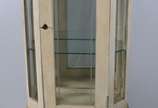 Vitrine de madeira patinada, parte inferior com... - Vitrine de madeira patinada, parte inferior com uma porta almofadada encimada por porta frontal e laterais de vidro, prateleiras internas também...