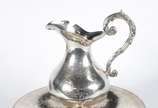 Elegante conjunto de jarra com bacia de prata f... - Elegante conjunto de jarra com bacia de prata francesa contrastada, prateiro G, fundo guilhochado e medalhão com monograma. Base ligeiramente to...