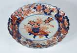 Bowl de porcelana japonesa Imari, decorado com ... - Bowl de porcelana japonesa Imari, decorado com motivos florais, borda recortada em gomos, desenhos no verso. Fio de cabelo.