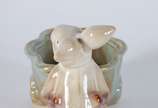 Escultura de porcelana representando coelho com... - Escultura de porcelana representando coelho com carrinho.