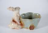 Escultura de porcelana representando coelho com... - Escultura de porcelana representando coelho com carrinho.