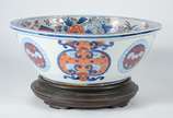 Bowl de porcelana oriental, parte interna decor... - Bowl de porcelana oriental, parte interna decorada com ânforas, flores e realces dourados, base de madeira.