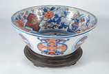 Bowl de porcelana oriental, parte interna decor... - Bowl de porcelana oriental, parte interna decorada com ânforas, flores e realces dourados, base de madeira.