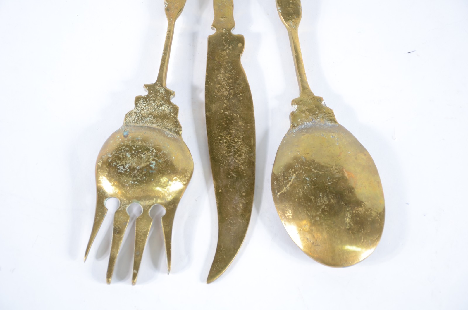 Conjunto com três talheres decorativos de metal dourado com suporte. - foto 8 de 9