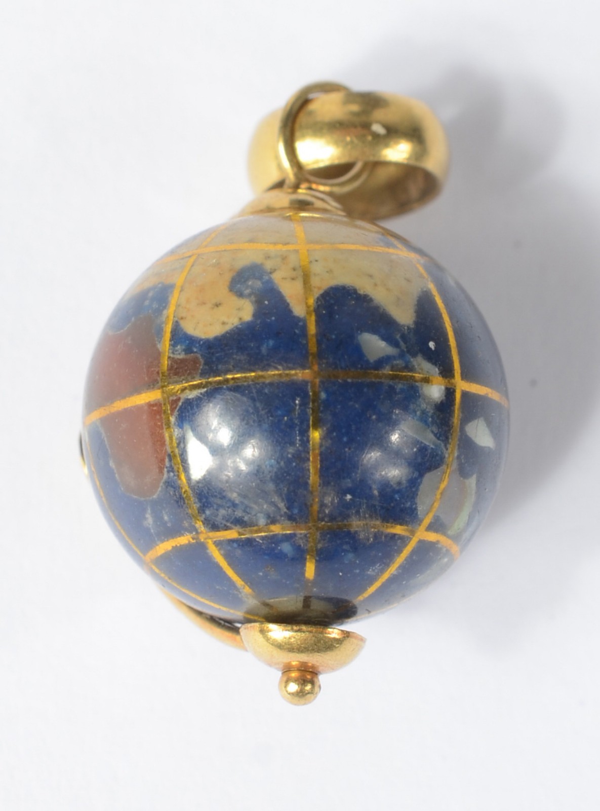 Pendente na forma de "globo" de ouro18 k., e esmalte. (Por motivos de... - foto 1 de 3