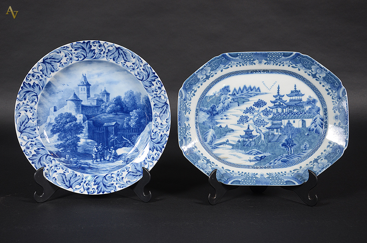 Dois pratos de porcelana decorados com cenas em azul e branco, sendo...
