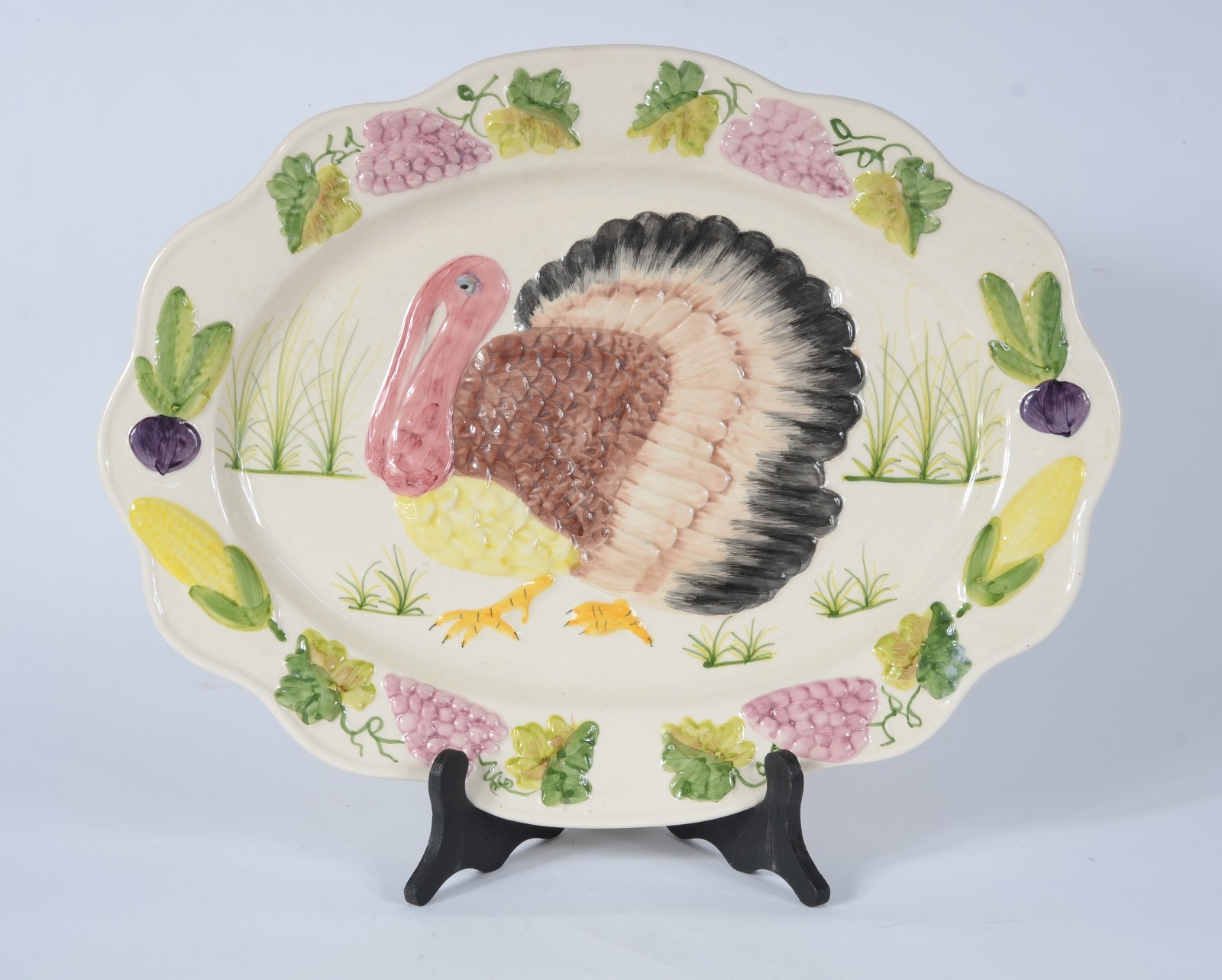 Travessa de cerâmica na cor bege, borda decorada com frutas e figura... - foto 1 de 3