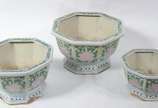 Conjunto com 3  cachepots de porcelana oriental... - Conjunto com 3  cachepots de porcelana oriental feitio oitavado, fundo branco com flores e folhagens em policromia. Desgastes.