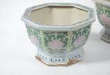 Conjunto com 3  cachepots de porcelana oriental... - Conjunto com 3  cachepots de porcelana oriental feitio oitavado, fundo branco com flores e folhagens em policromia. Desgastes.