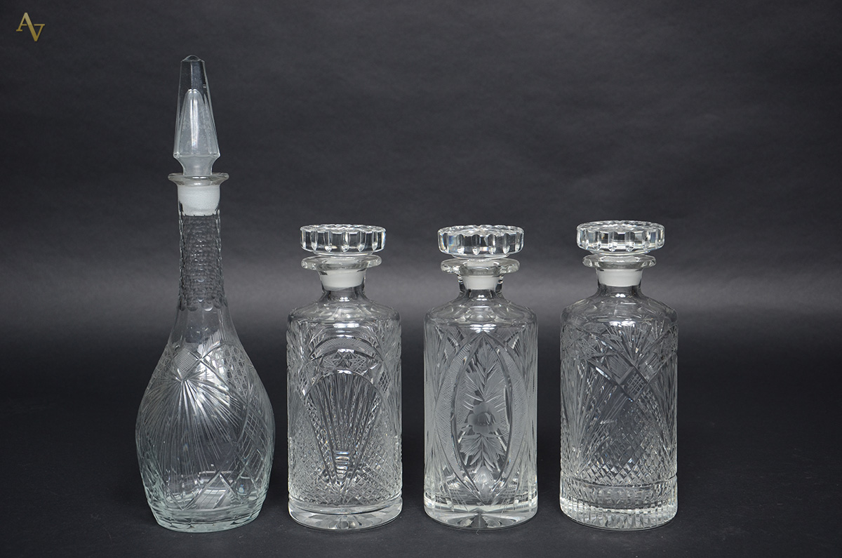 Quatro garrafas de cristal europeu lapidado. Alturas de 25 a 40 cm.