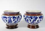 Par de cachepots de cerâmica decoração floral e... - Par de cachepots de cerâmica decoração floral em tons de azul, bases de madeira (um deles com fio de cabelo)