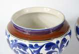 Par de cachepots de cerâmica decoração floral e... - Par de cachepots de cerâmica decoração floral em tons de azul, bases de madeira (um deles com fio de cabelo)