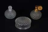 René Lalique (1860-1945),  - Conjunto para toilette de cristal frances, composto de poseira e dois perfumeiros trabalhados em relevo, da linha "Cactus". Assinados na base.