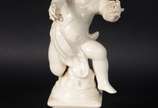 Três esculturas de porcelana, sendo : Anjo sobr... - Três esculturas de porcelana, sendo : Anjo sobre pedestal (dedos com defeito); Cão de Fó na cor azul (restauro); placa com rostos de anjos em po...