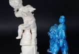 Três esculturas de porcelana, sendo : Anjo sobr... - Três esculturas de porcelana, sendo : Anjo sobre pedestal (dedos com defeito); Cão de Fó na cor azul (restauro); placa com rostos de anjos em po...