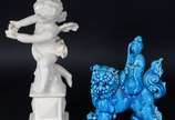 Três esculturas de porcelana, sendo : Anjo sobr... - Três esculturas de porcelana, sendo : Anjo sobre pedestal (dedos com defeito); Cão de Fó na cor azul (restauro); placa com rostos de anjos em po...