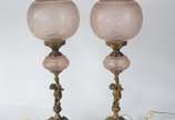 Par de luminárias de metal dourado decoradas co... - Par de luminárias de metal dourado decoradas com figuras de "Pucci"nas bases, globos de vidro fosco rosado.