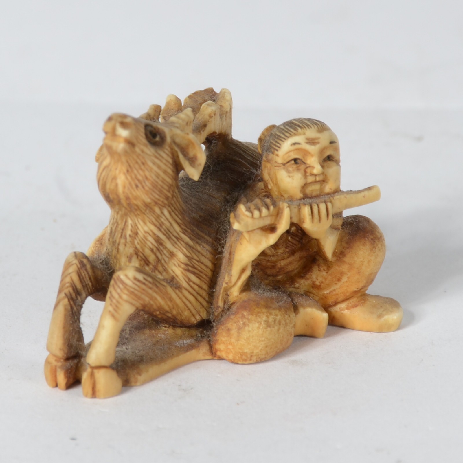 Netsuke de marfim japones representando figura masculina com flauta e... - foto 2 de 6