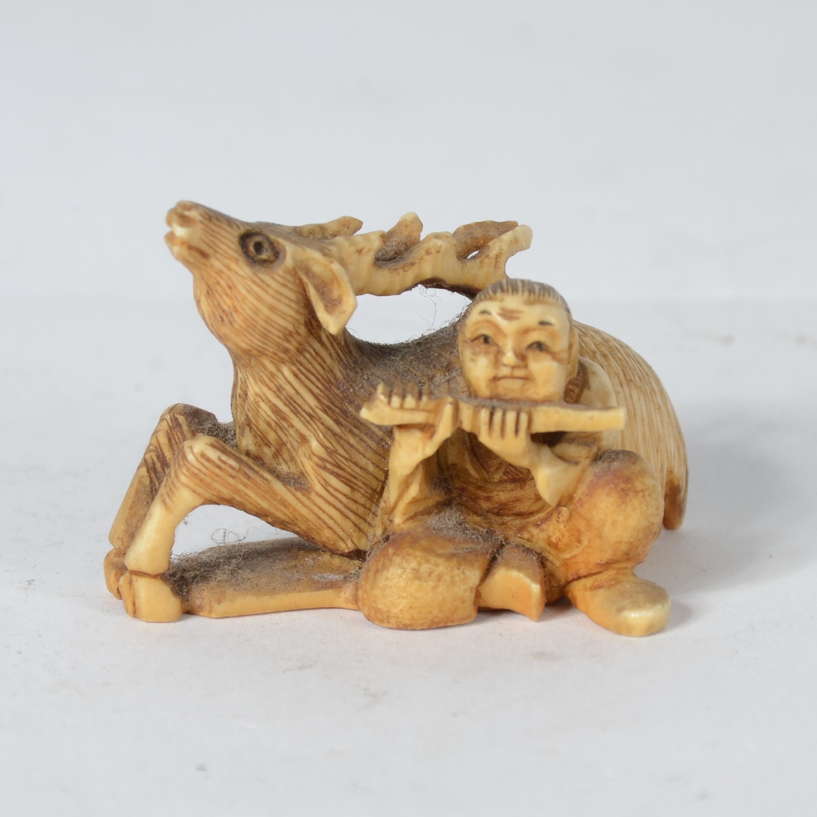 Netsuke de marfim japones representando figura masculina com flauta e... - foto 1 de 6