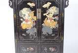 Movel chines de lacca negra decorada com figura... - Movel chines de lacca negra decorada com figuras de crianças e peixes em policromia, 2 portas com prateleira interna e duas gavetinhas na parte ...