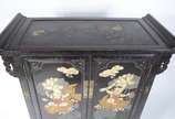 Movel chines de lacca negra decorada com figura... - Movel chines de lacca negra decorada com figuras de crianças e peixes em policromia, 2 portas com prateleira interna e duas gavetinhas na parte ...