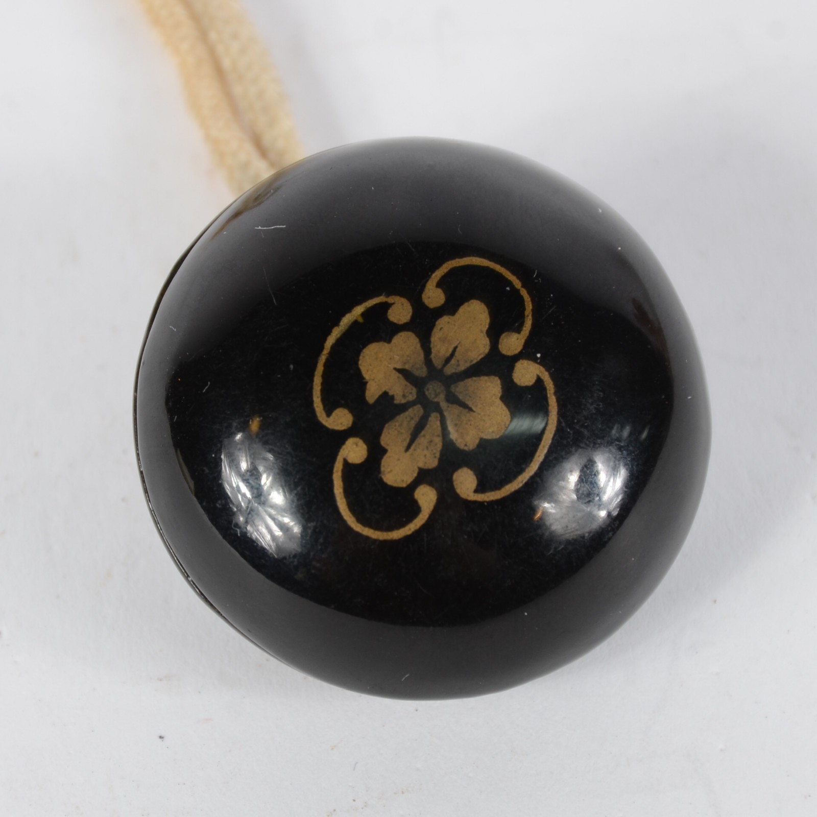 Netsuke estilo “Manju”, em laca preta com emblema floral dourado, de... - foto 1 de 5