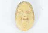 Raro netsuke para criança, esculpido em marfim,... - Raro netsuke para criança, esculpido em marfim, representando máscara do teatro Kabuki, séc. XIX. Assinado no verso.