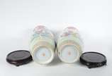 Par de vasos de porcelana chinesa decorados com... - Par de vasos de porcelana chinesa decorados com figuras típicas em policromia e guirlandas florais, acompanham peanhas de madeira.