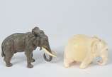 Duas pequenas esculturas representando elefante... - Duas pequenas esculturas representando elefantes, sendo uma de marfim e outra de bronze com presas de marfim.