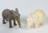 Duas pequenas esculturas representando elefante... - Duas pequenas esculturas representando elefantes, sendo uma de marfim e outra de bronze com presas de marfim.