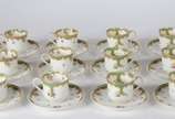 Limoges (1771),  - Conjunto com 12 xícaras com pires para café de porcelana francesa, decoradas com flores em policromia e guirlandas na cor verde e frisos dourados (uma