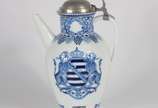 Meissen (1708),  - Jarra para vinho de porcelana alemã de Meissen decorada com brazão e guirlandas com cachos de uvas e folhas de parreira em azul e branco, marcas de Me