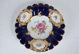 Meissen (1708),  - Elegante prato de porcelana alemã de Meissen decorado com flores em policromia com realces dourados sobre fundo azul cobalto, borda em gomos.