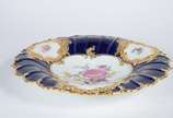 Meissen (1708),  - Elegante prato de porcelana alemã de Meissen decorado com flores em policromia com realces dourados sobre fundo azul cobalto, borda em gomos.