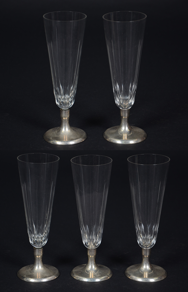 Cinco flutes de cristal com bases de prata contrastada.