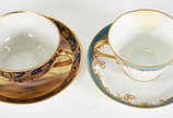 Duas xícaras de chá em porcelana, sendo uma jap... - Duas xícaras de chá em porcelana, sendo uma japonesa decorada com cena do deserto em policromia e dourado, e outra francesa com guirlandas , bor...