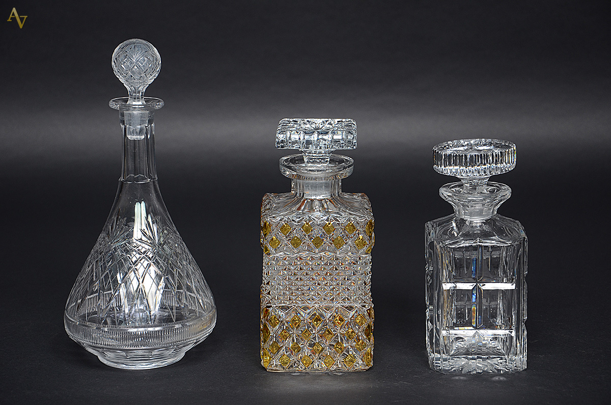 Três garrafas de cristal lapidado (uma com tampa lascada). Alturas 20...
