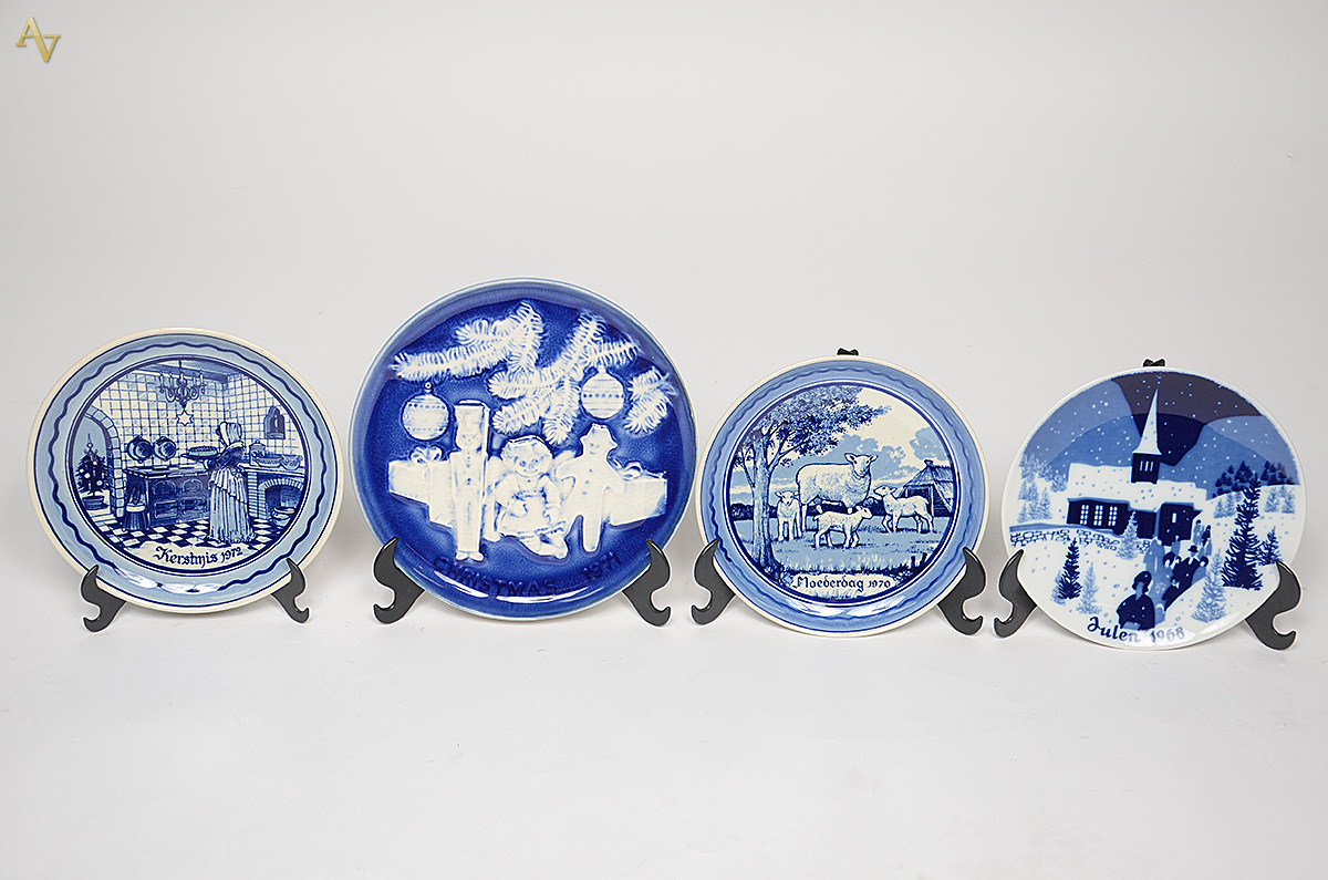 Quatro pratos de porcelana decorados com motivos festivos, sendo três...