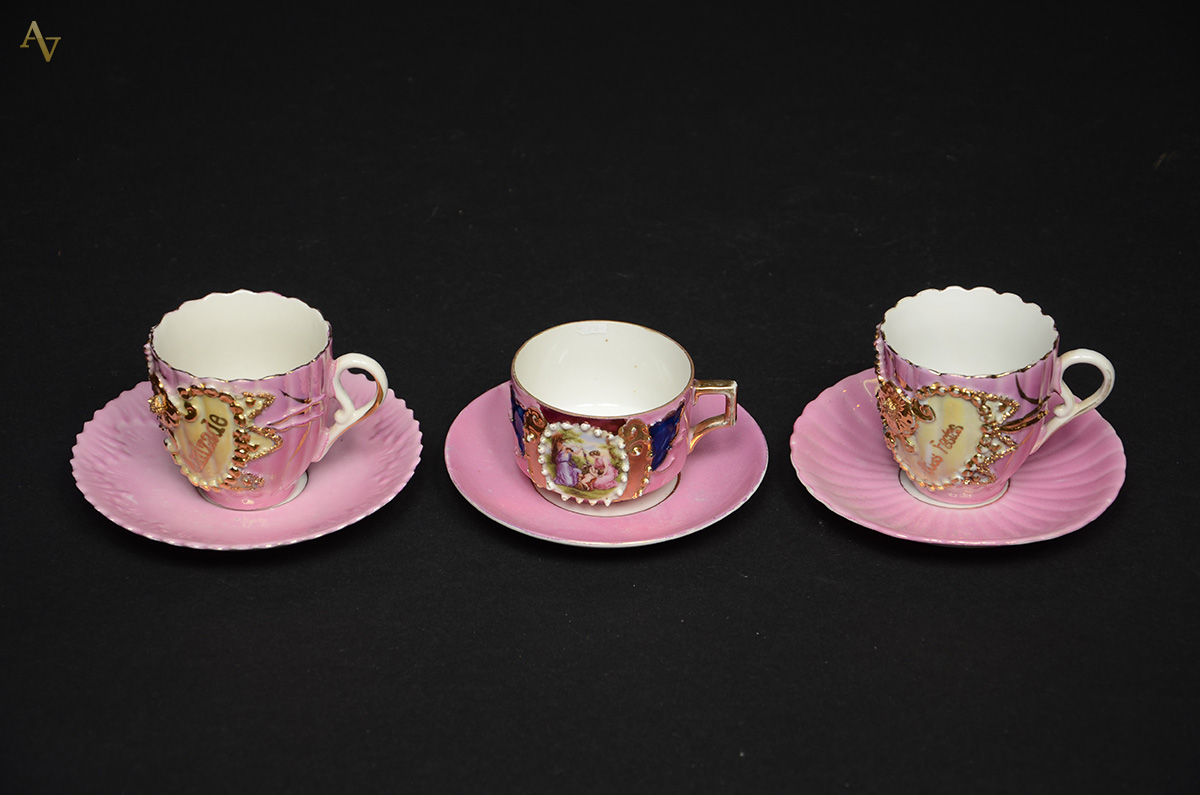 Três xícaras diversas para chá com pires de porcelana na cor rosa...