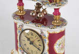 Relógio decorativo de mesa em porcelana policro... - Relógio decorativo de mesa em porcelana policromada com realces dourados,  à pilha.