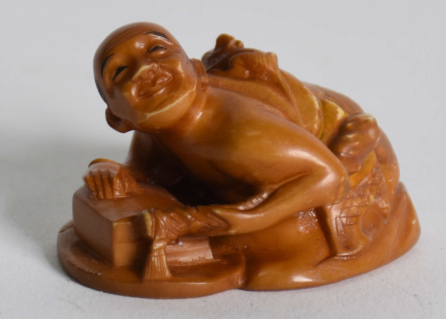 Netsuke de marfim representando Homem com ratinho nas costas... - foto 1 de 3