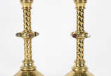 Par de castiçais em metal dourado  ricamente tr... - Par de castiçais em metal dourado  ricamente trabalhados em serpentinas vazadas, aplicações de pedras coloridas, bases com inscrições sacras.