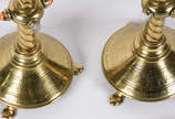 Par de castiçais em metal dourado  ricamente tr... - Par de castiçais em metal dourado  ricamente trabalhados em serpentinas vazadas, aplicações de pedras coloridas, bases com inscrições sacras.