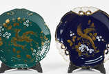 Duas fruteiras de porcelana Européia nas cores ... - Duas fruteiras de porcelana Européia nas cores verde e azul com realces dourados, tres pes baixos cada.