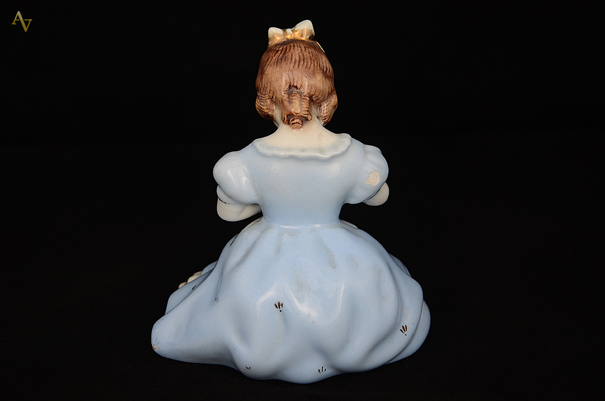 Escultura de porcelana representando menina. Altura 14,5 cm (com... - foto 2 de 3